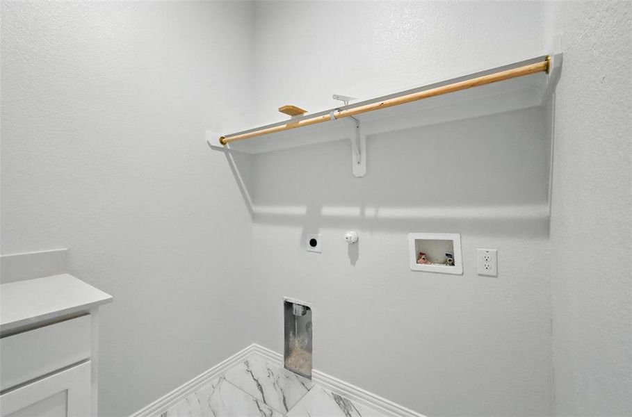 Washroom featuring hookup for a washing machine, hookup for a gas dryer, marble finish flooring, hookup for an electric dryer, and a textured wall