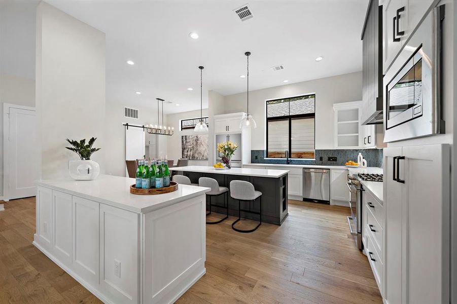 The stunning double island kitchen is every home chef's dream! Complete with GE Cafe appliances, Kalamera wine fridge, architectural vent hood, and abundant storage.