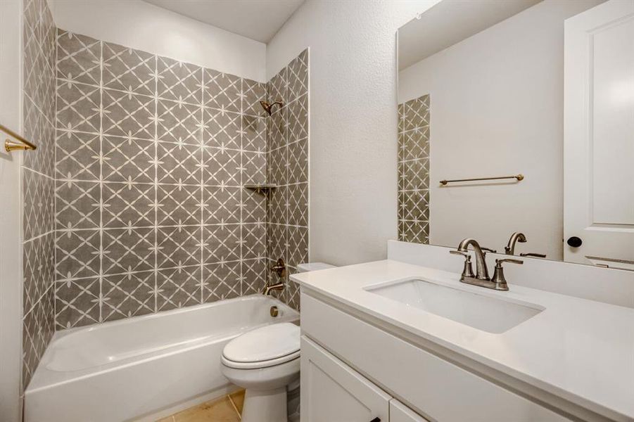 Bathroom featuring shower / tub combination, vanity, and light tile patterned floors