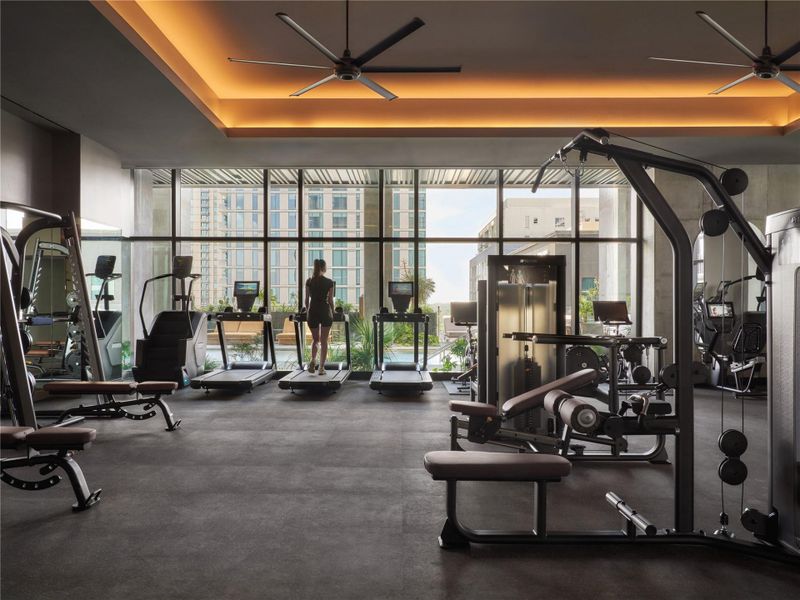 Floor-to-ceiling windows frame cityscape views in this modern fitness center with tray ceilings. Floor-to-ceiling windows frame cityscape views in this modern fitness center with tray ceilings.