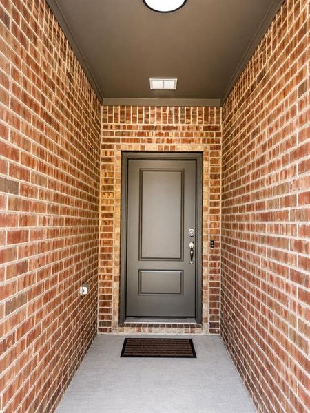 Brick entryway with a recessed ceiling and concrete flooring