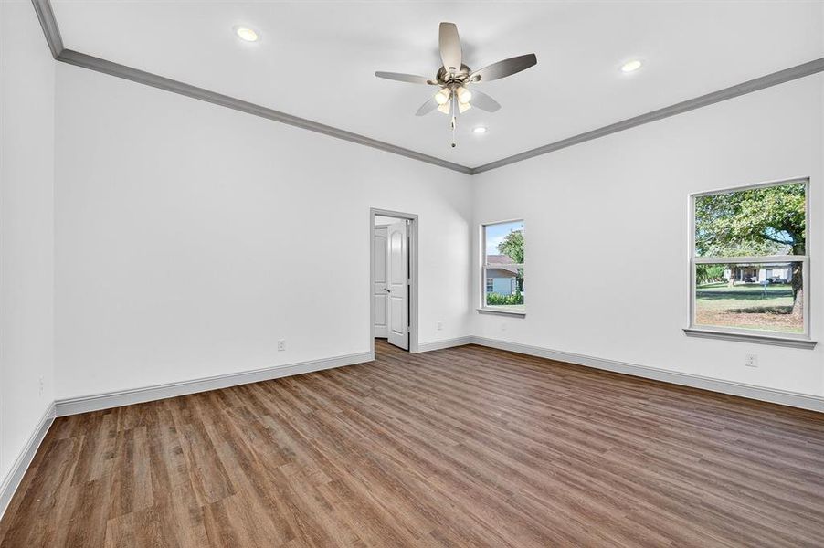 Empty room featuring crown molding, wood finished floors, recessed lighting, and a ceiling fan