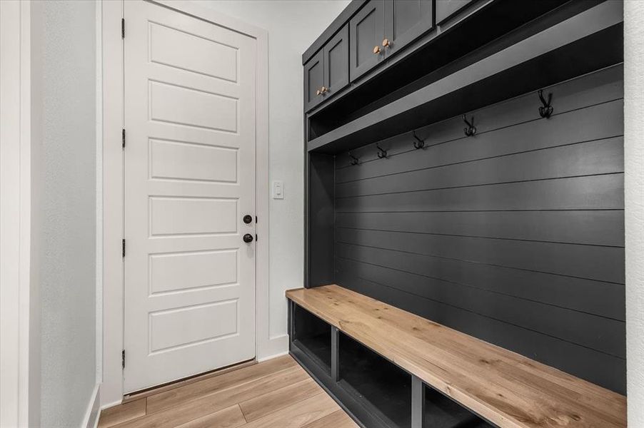 Mud room leads to garage through door.  To the left is entrance to laundry room and behind is kitchen.