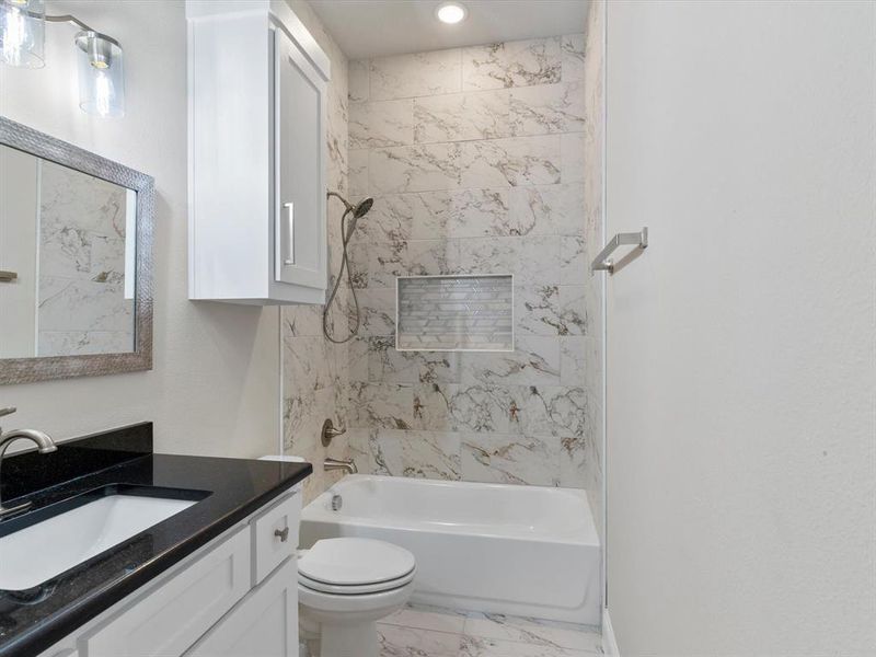 Full bathroom with vanity, tiled shower / bath, and toilet