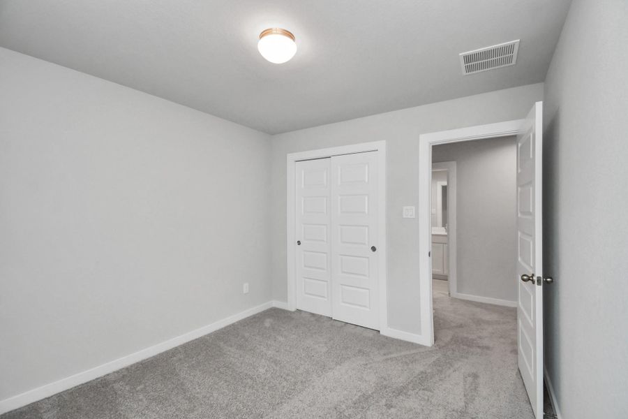 Generously sized secondary bedrooms featuring spacious closets, soft and inviting carpeting underfoot, large windows allowing plenty of natural light, and the added touch of privacy blinds for your personal retreat.