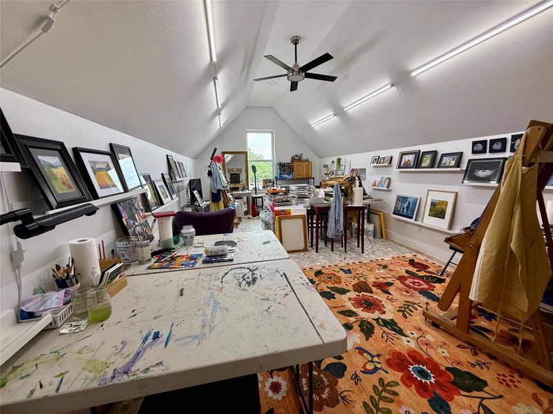 Vaulted ceiling room featuring a ceiling fan, recessed lighting, and wall-mounted shelving