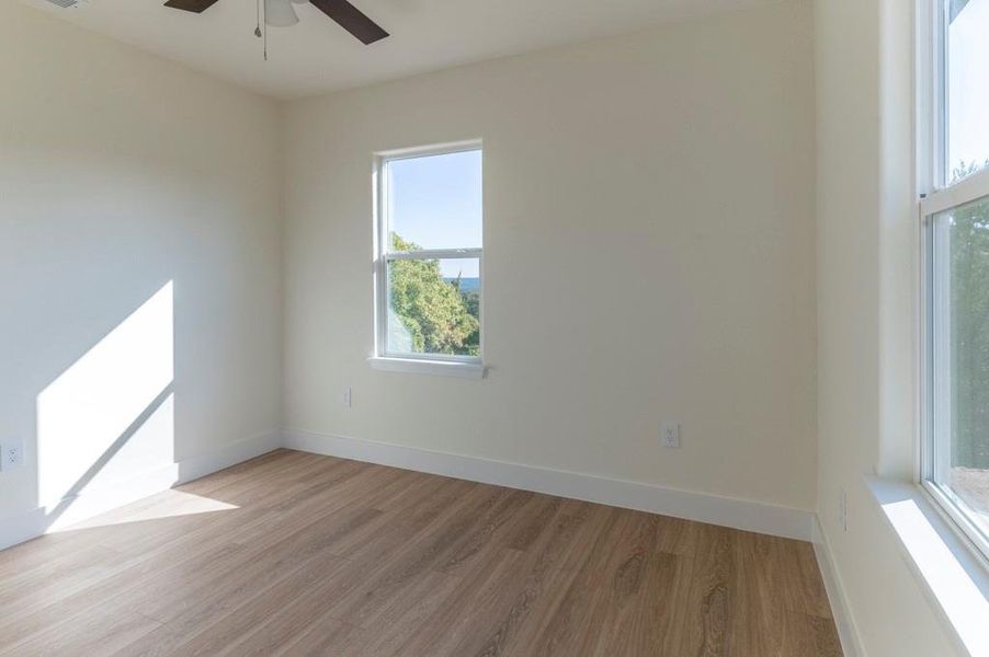 Unfurnished room featuring light wood-type flooring and ceiling fan