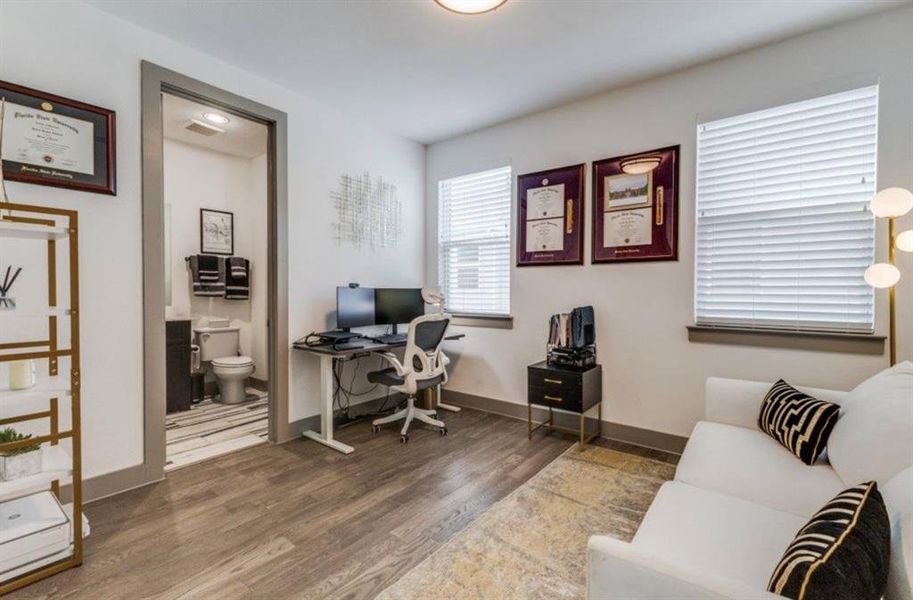 Bedroom with wood finished floors and an en suite bathroom.