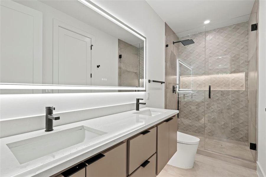 Bathroom featuring double vanity, a stall shower, recessed lighting, and tile patterned floors