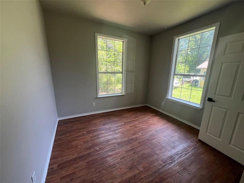 Spare room with plenty of natural light and dark wood-type flooring Spare room with plenty of natural light and dark wood-type flooring