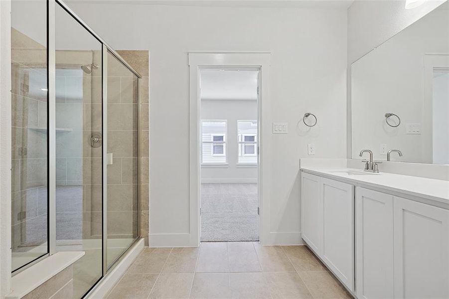 Bathroom with an enclosed shower, vanity, and tile patterned flooring Bathroom with an enclosed shower, vanity, and tile patterned flooring