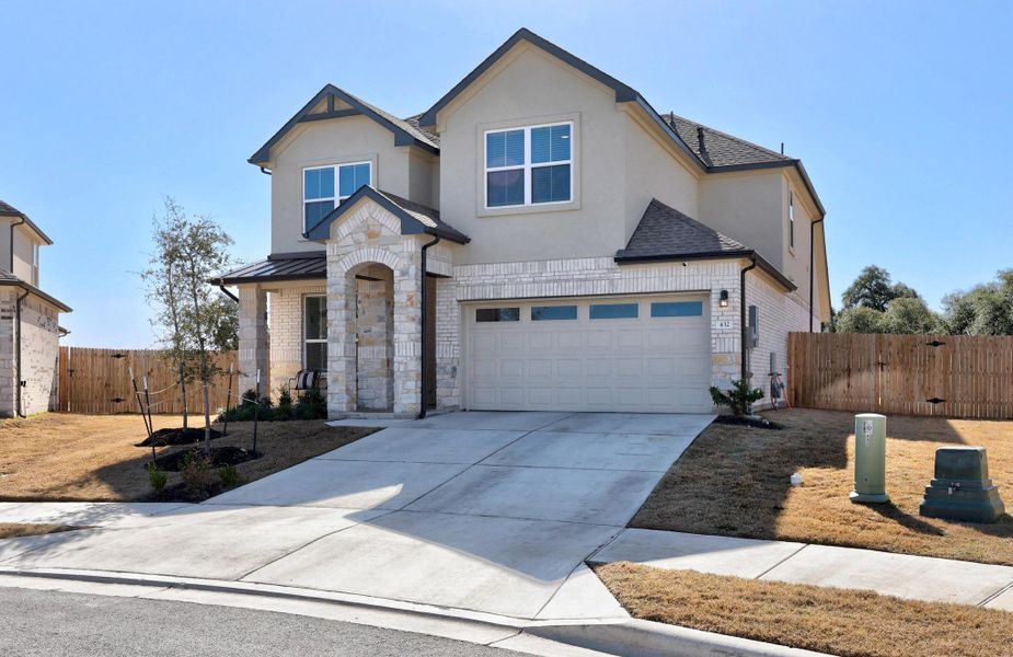 View of front of house with a shingled roof, concrete driveway, a gate, fence, and stone siding