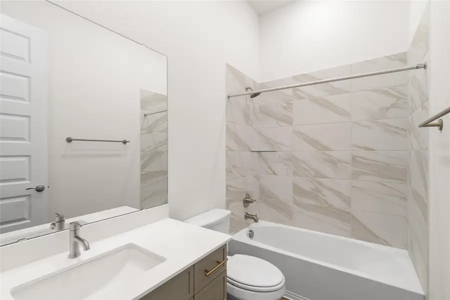 A bathroom features a single vanity, a spacious bathtub, and chic tiled shower walls. A bathroom features a single vanity, a spacious bathtub, and chic tiled shower walls.