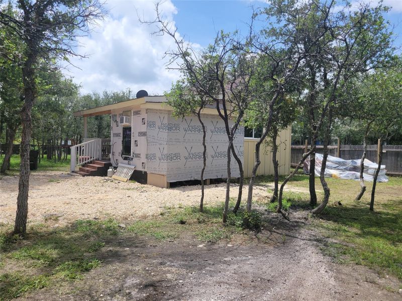 A partially finished new construction nestled among mature trees awaits completion. A partially finished new construction nestled among mature trees awaits completion.