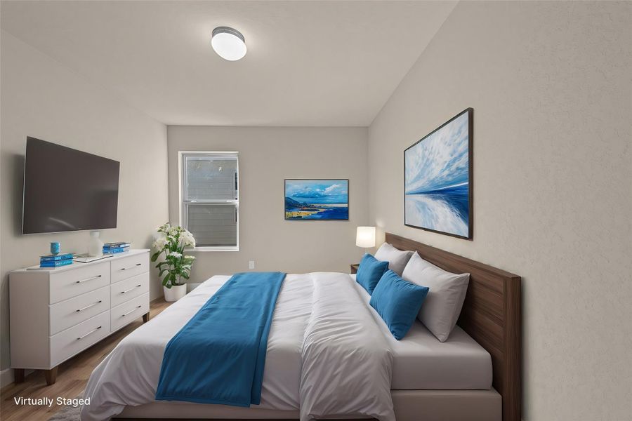 Hardwood flooring and abundant natural light create a peaceful and inviting bedroom retreat.