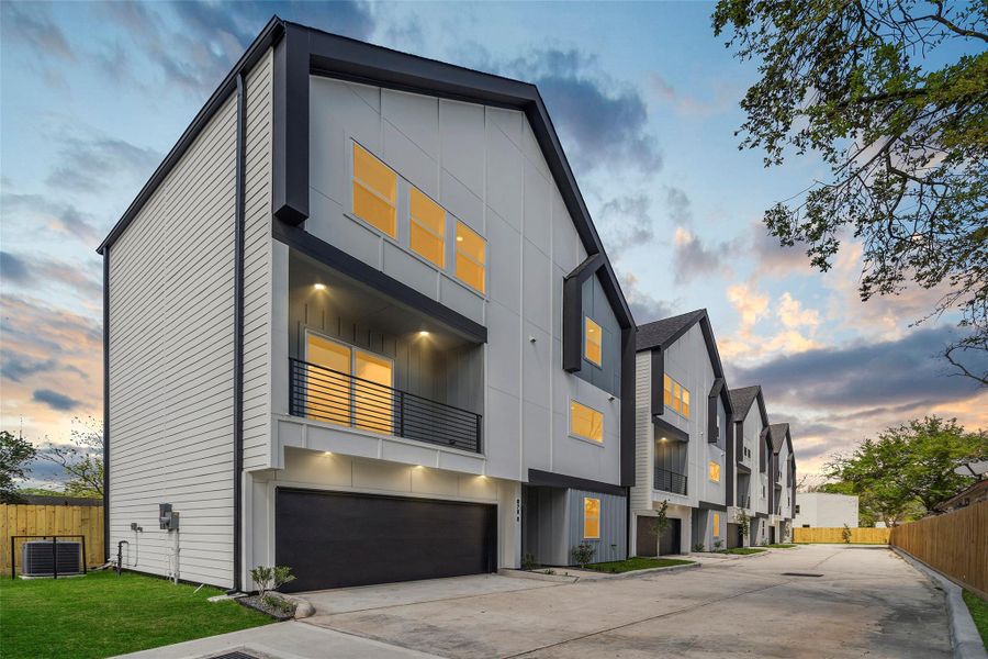 Welcome to your home at 870 W. Little York Road, #D.  This modern multi-story townhouse has a sleek design, featuring large windows and a balcony. The unit has an attached garage and is situated on a quiet, well-maintained street, perfect for comfortable urban living.