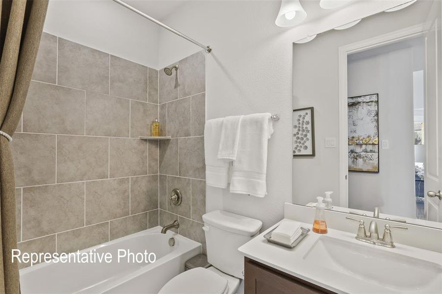 Full bathroom with vanity, toilet, and tiled shower / bath combo