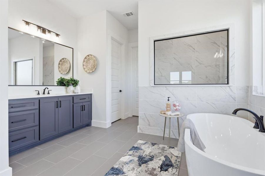 Ensuite Bathroom with dual vanities with sinks and linen closet