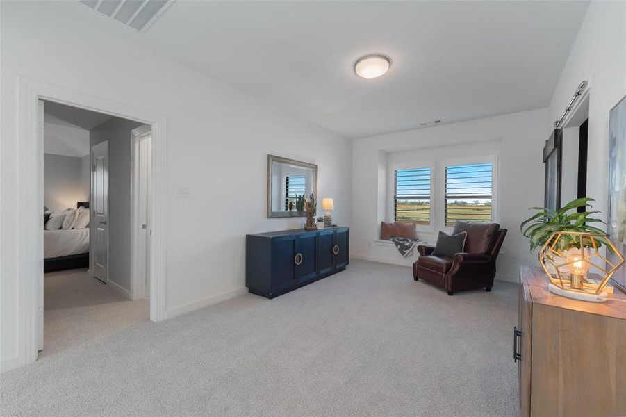 Living area featuring light carpet, visible vents, and baseboards