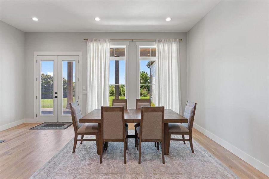 Dining room with french doors and light wood-type flooring