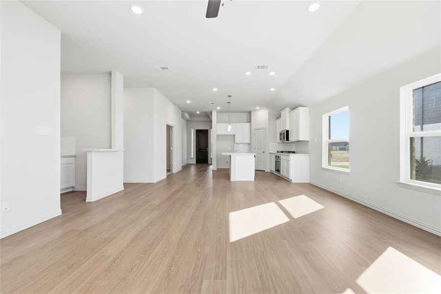 Unfurnished living room with light wood-type flooring, a ceiling fan, and recessed lighting Unfurnished living room with light wood-type flooring, a ceiling fan, and recessed lighting