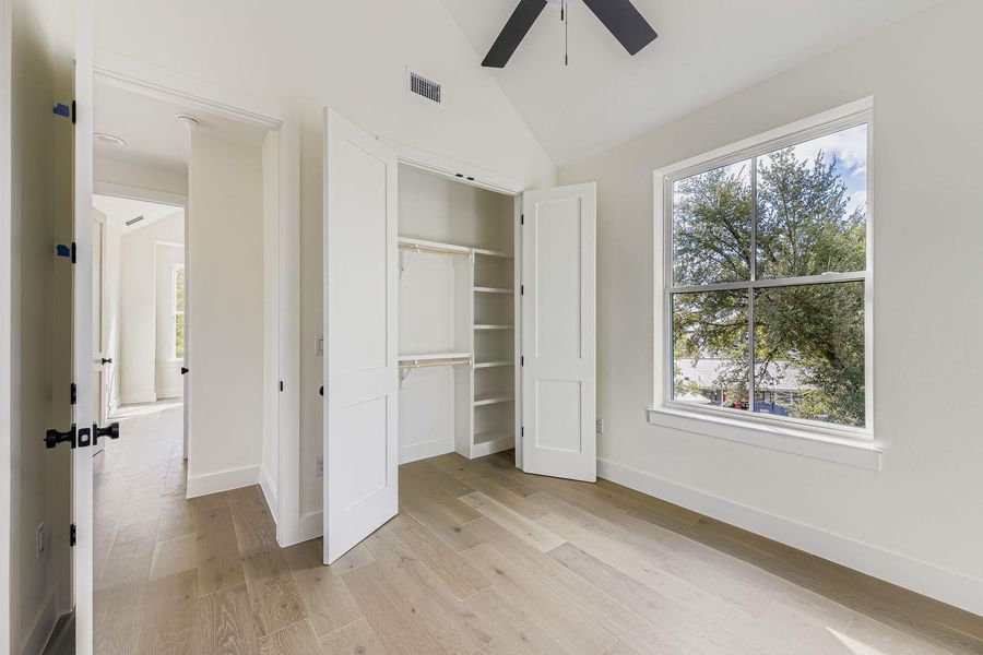 Unfurnished bedroom featuring light wood-style floors, a closet, lofted ceiling, and ceiling fan Unfurnished bedroom featuring light wood-style floors, a closet, lofted ceiling, and ceiling fan