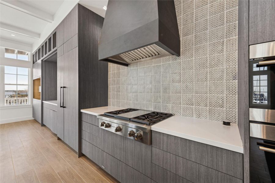 Kitchen decked out with Wolf appliances, sleek contemporary design upgrades and plenty of storage.