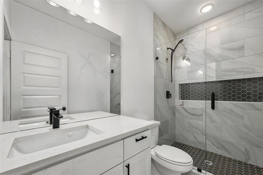 Full bathroom featuring a marble finish shower and vanity
