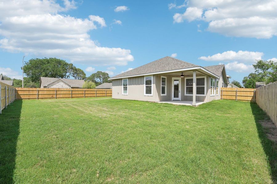 Rear view of property with a fenced backyard, a shingled roof, ceiling fan, a patio, and a lawn Rear view of property with a fenced backyard, a shingled roof, ceiling fan, a patio, and a lawn