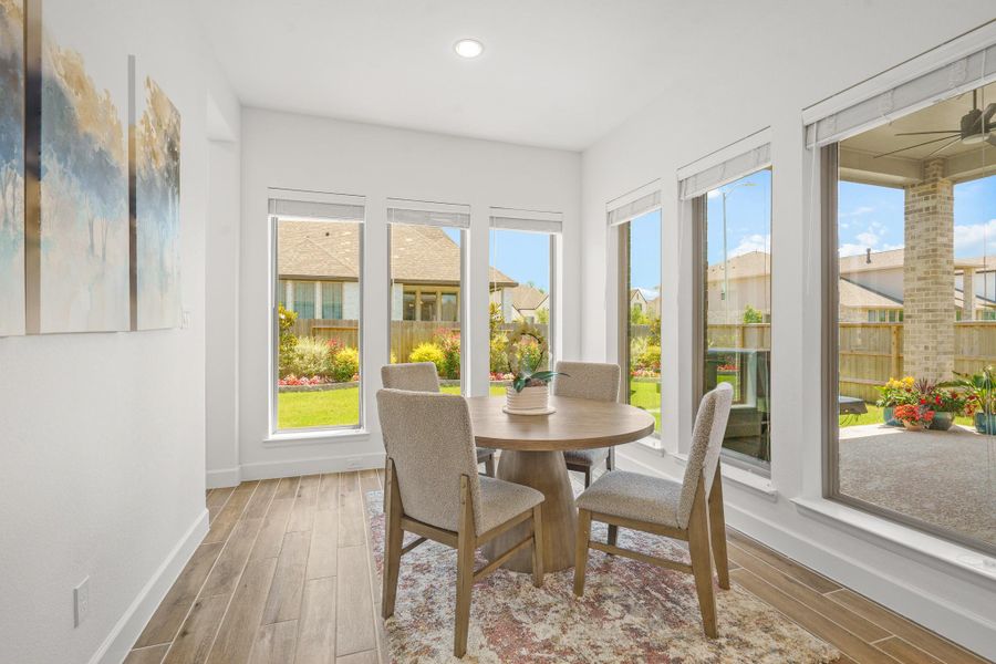 Bright dining area with large windows creates a cozy setting for a morning cup of coffee enjoying the views of the backyard.