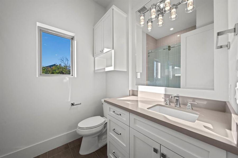 This elegant ensuite full bathroom attached to the Third bedroom features a modern vanity with countertops and ample storage. The large mirror, accented by contemporary light fixtures, adds a touch of sophistication. A bright window brings in natural light, enhancing the airy and fresh feel of the space. Perfectly designed for comfort and functionality, this ensuite offers a private and stylish retreat.