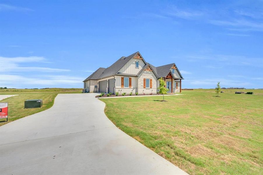 Craftsman-style house featuring a front yard and a garage