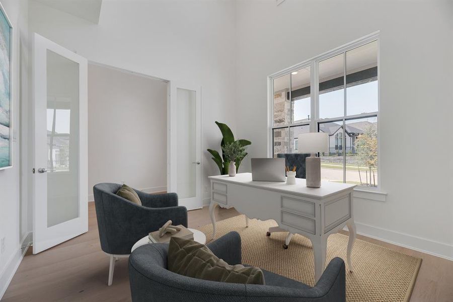 Office with wood finished floors and a towering ceiling