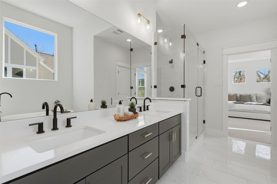 Experience luxury in this pristine primary bath, featuring a sleek double sink, elegant glass shower, and abundant natural light for a refreshing retreat. Experience luxury in this pristine primary bath, featuring a sleek double sink, elegant glass shower, and abundant natural light for a refreshing retreat.