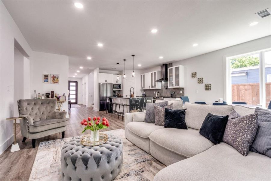 Living area with light wood finished floors, plenty of natural light, and recessed lighting