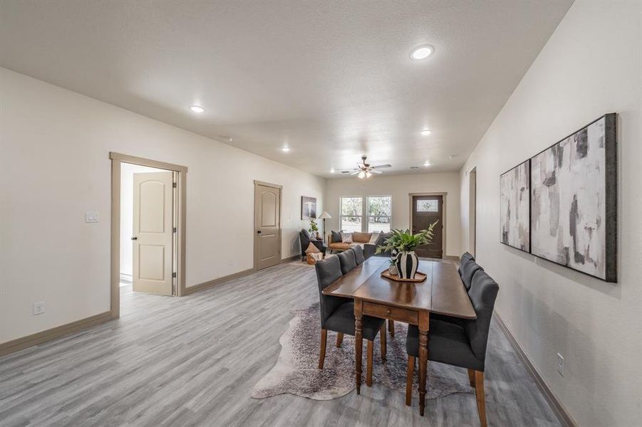 Dining room with light wood-type flooring, a ceiling fan, and recessed lighting