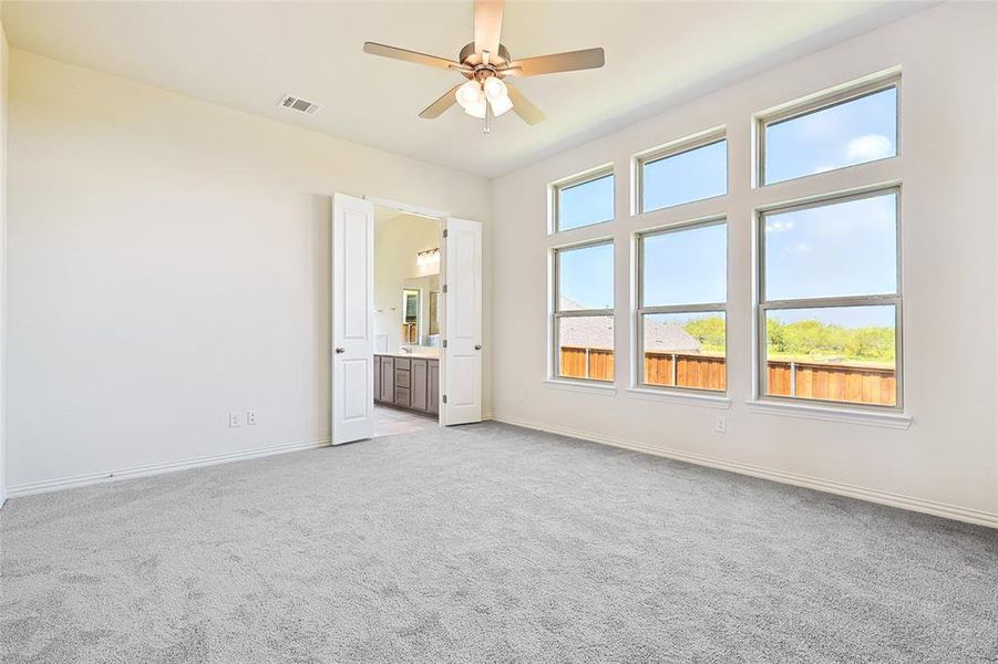 Carpeted spare room with ceiling fan