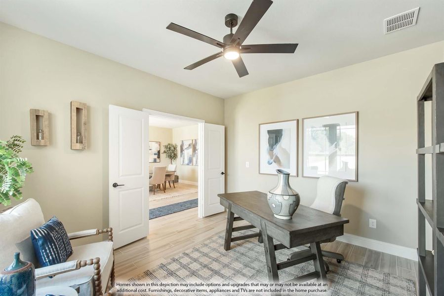 Home office with wood desk, ceiling fan, hardwood floors, and open double doors leading to dining room Home office with wood desk, ceiling fan, hardwood floors, and open double doors leading to dining room