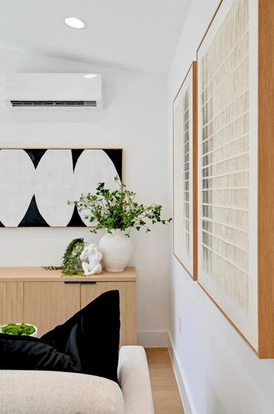 Living area with wood finished floors, recessed lighting, and a wall mounted air conditioner