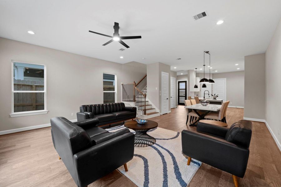 Inviting living area featuring an open layout and large windows that create a light-filled atmosphere. Image depicts home as-is.