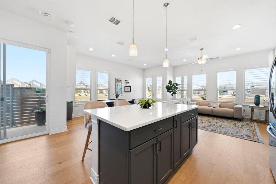 Gleaming hardwood floors and a massive center island anchor this expansive open-concept living space. Gleaming hardwood floors and a massive center island anchor this expansive open-concept living space.