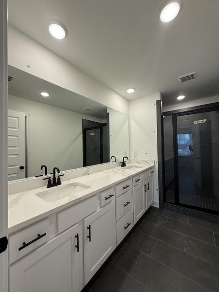 Full bathroom with double vanity, a stall shower, recessed lighting, and dark tile patterned flooring