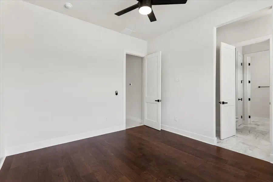 Unfurnished bedroom with baseboards, wood finished floors, and ceiling fan Unfurnished bedroom with baseboards, wood finished floors, and ceiling fan