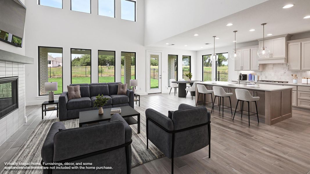 Living area with wood finished floors, recessed lighting, a fireplace, and a high ceiling Living area with wood finished floors, recessed lighting, a fireplace, and a high ceiling
