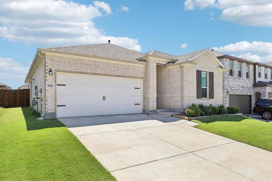 View of front of property featuring a shingled roof, a front lawn, concrete driveway, and a garage View of front of property featuring a shingled roof, a front lawn, concrete driveway, and a garage