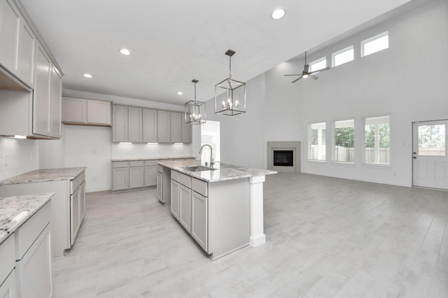 The kitchen is a culinary haven, featuring granite countertops, a tile backsplash, stainless steel appliances, 42” upper cabinets, and undercabinet lighting. Sample photo of completed home with similar floor plan. Actual colors and selections may vary.