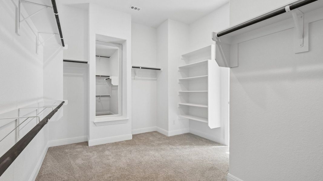 The walk-in closet in the Primary Bedroom of the Brown floorplan at Retreat at San Gabriel - Representative Photo The walk-in closet in the Primary Bedroom of the Brown floorplan at Retreat at San Gabriel - Representative Photo