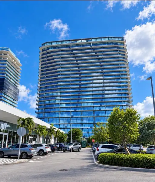 High-rise residential tower featuring a glass facade, private balconies, and concrete structural elements High-rise residential tower featuring a glass facade, private balconies, and concrete structural elements