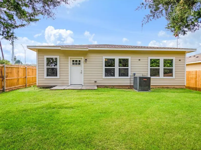 Expansive green lawn with a privacy fence