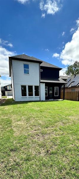 Rear view of property featuring yard